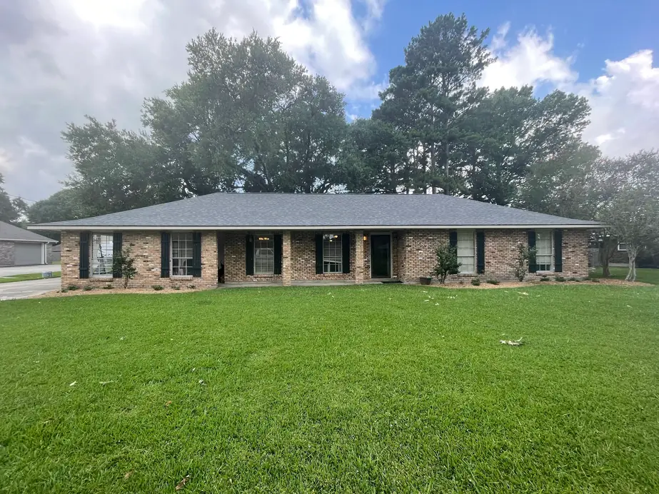 Single-storey brick home with a fresh gray hip roof and a wide front lawn